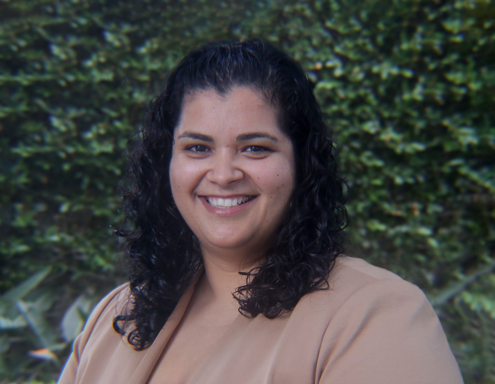 Headshot of woman sitting smiling at the camera.